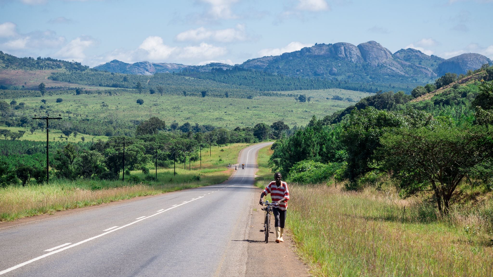 A men walking beside its bike in Africa Samuel Roy - Arkel's Ambassador
